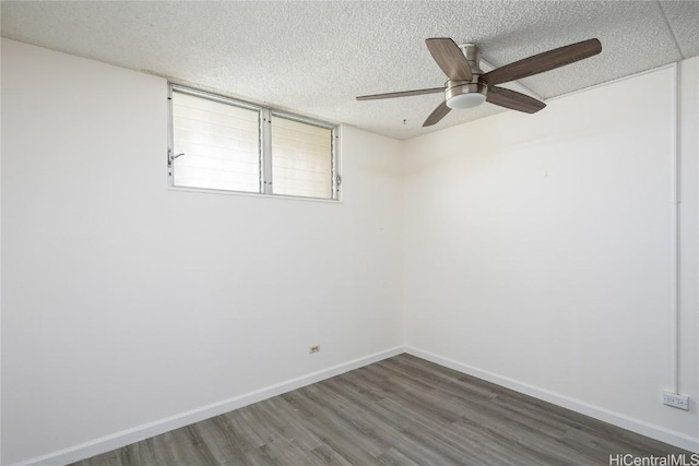 spare room with a textured ceiling, dark hardwood / wood-style floors, and ceiling fan