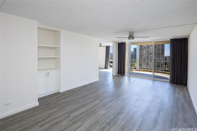 unfurnished living room with built in shelves, a textured ceiling, dark hardwood / wood-style floors, and floor to ceiling windows