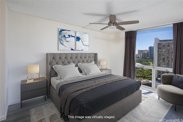 bedroom with multiple windows, wood-type flooring, access to exterior, and ceiling fan