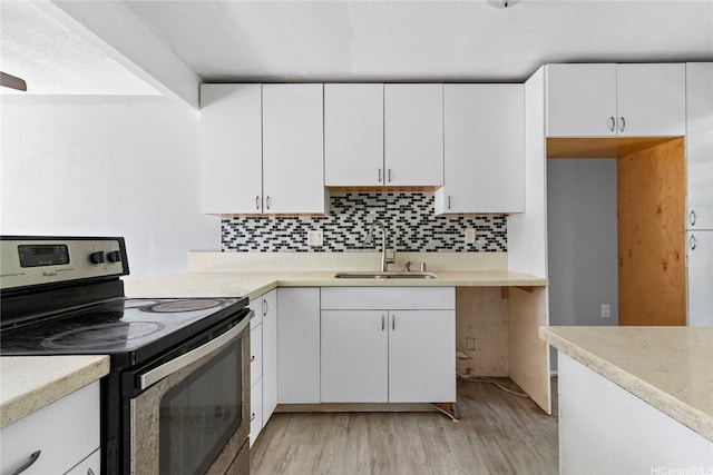 92-988 Panana St Unit 1, Kapolei, HI 96707 - kitchen featuring stainless steel range with electric cooktop, light wood-style floors, white cabinets, light countertops, and decorative backsplash