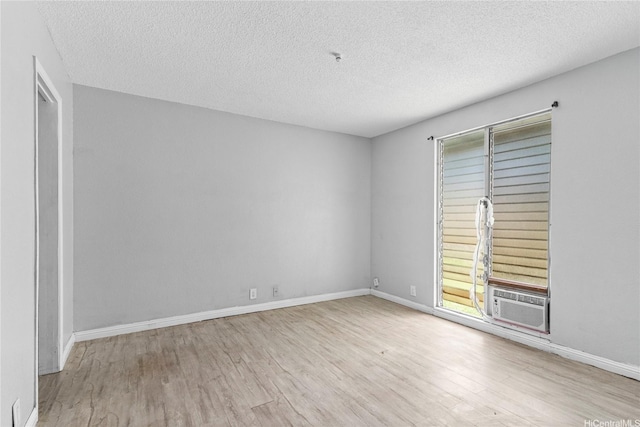 92-988 Panana St Unit 1, Kapolei, HI 96707 - unfurnished room featuring cooling unit, wood finished floors, a textured ceiling, and healthy amount of natural light