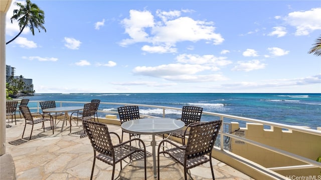 view of patio with a water view and a beach view