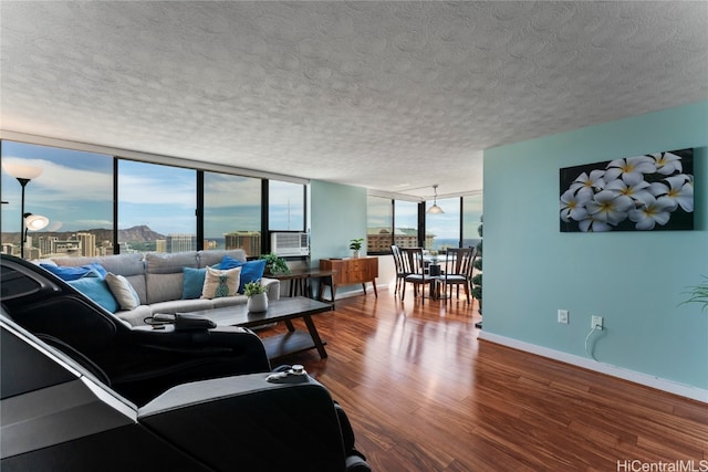 living room with a wall of windows, a textured ceiling, wood-type flooring, and cooling unit