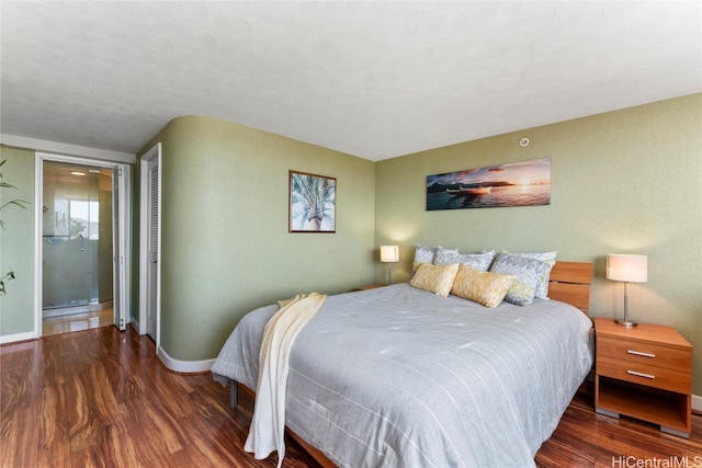 bedroom with a textured ceiling and dark hardwood / wood-style flooring