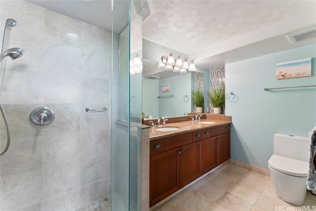 bathroom with vanity, a textured ceiling, toilet, and tiled shower