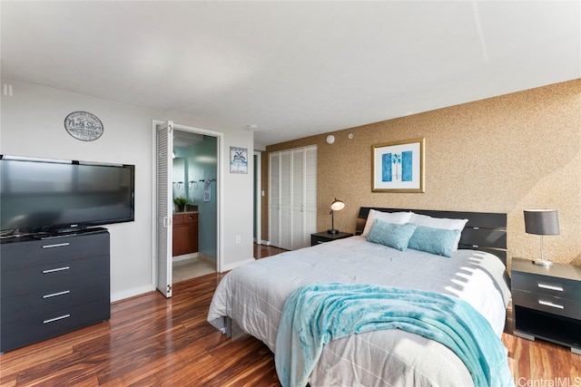 bedroom with connected bathroom and dark hardwood / wood-style flooring