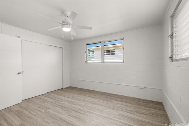 unfurnished bedroom featuring ceiling fan, light wood-type flooring, and a closet