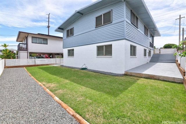 view of side of home with a yard and a patio