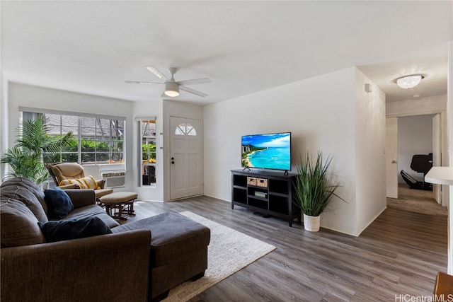 living room with cooling unit, hardwood / wood-style flooring, and ceiling fan