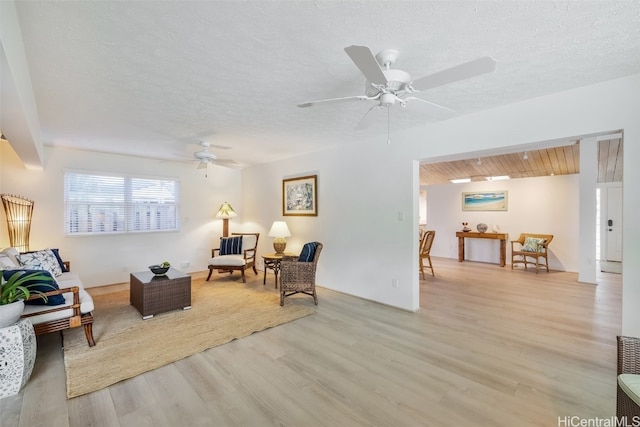 sitting room with ceiling fan, a textured ceiling, and light hardwood / wood-style flooring