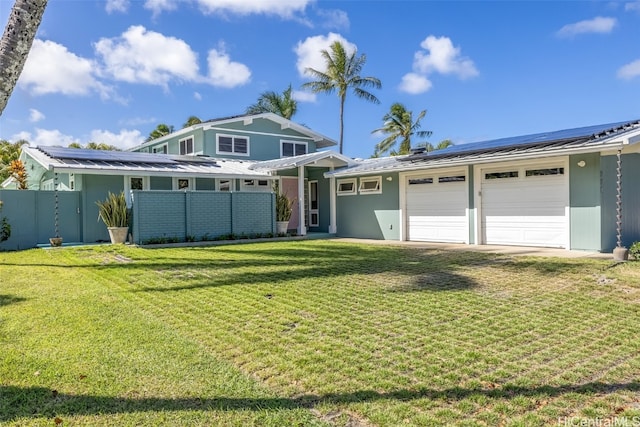 view of front of house with a garage, a front lawn, and solar panels