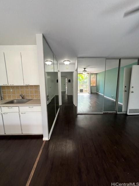 interior space featuring baseboards, dark wood finished floors, and a sink