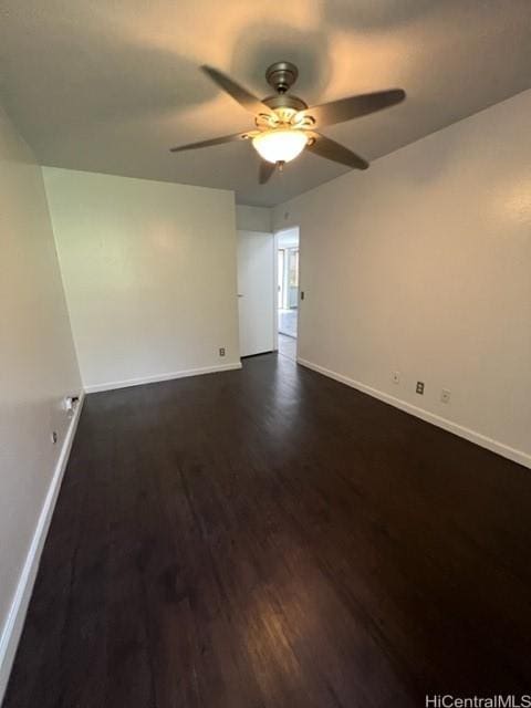 empty room with dark wood-style flooring, ceiling fan, and baseboards