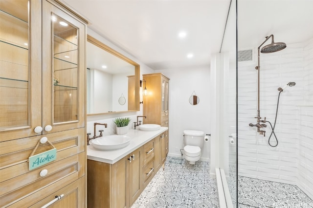 full bathroom with double vanity, baseboards, a sink, and tiled shower