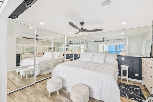 bedroom with a closet, ceiling fan, and light hardwood / wood-style flooring