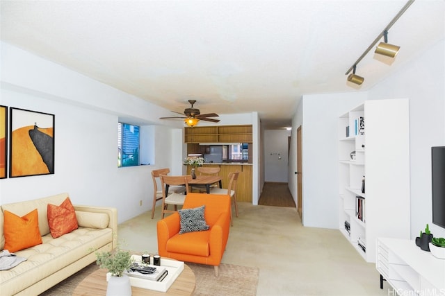 carpeted living room with a textured ceiling, track lighting, and ceiling fan