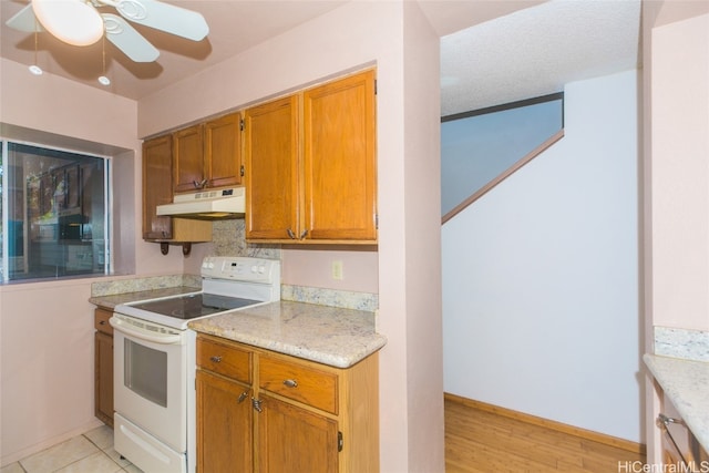 kitchen with electric stove, light stone counters, a textured ceiling, light hardwood / wood-style floors, and ceiling fan