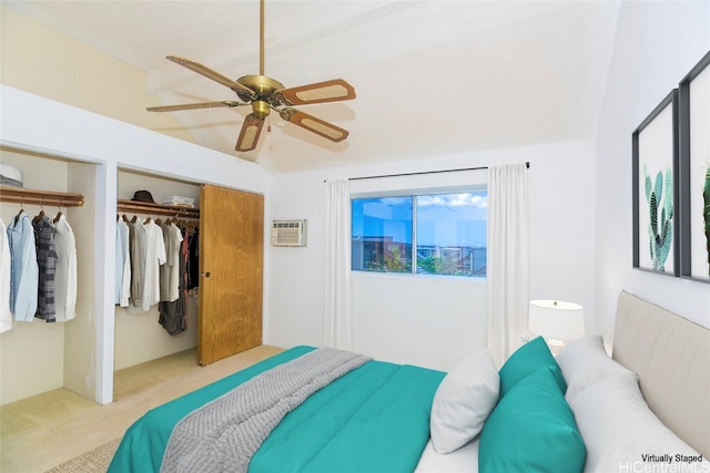 carpeted bedroom featuring ceiling fan, multiple closets, and a wall mounted AC