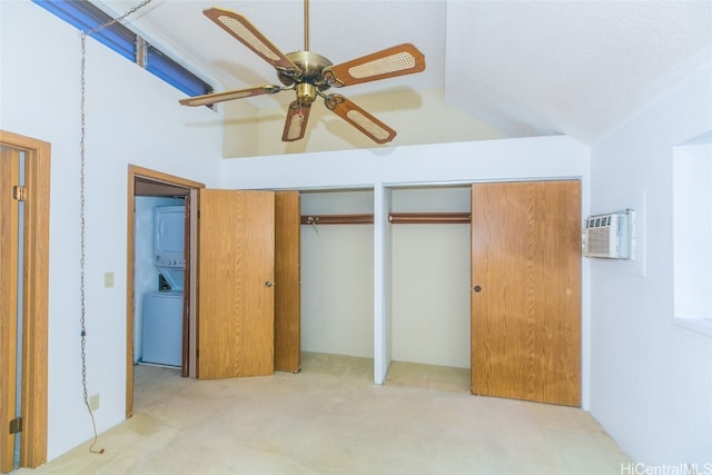 unfurnished bedroom with lofted ceiling, stacked washer and clothes dryer, an AC wall unit, multiple closets, and ceiling fan