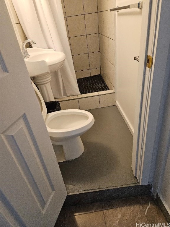 bathroom with toilet, a shower with curtain, and sink