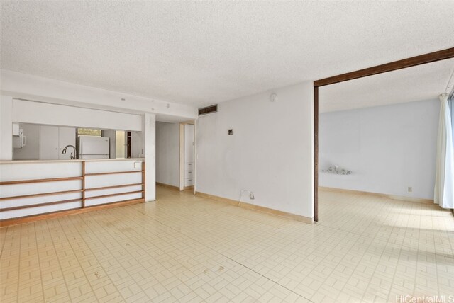 unfurnished room with a textured ceiling