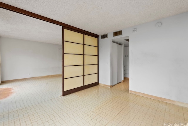 spare room with a textured ceiling