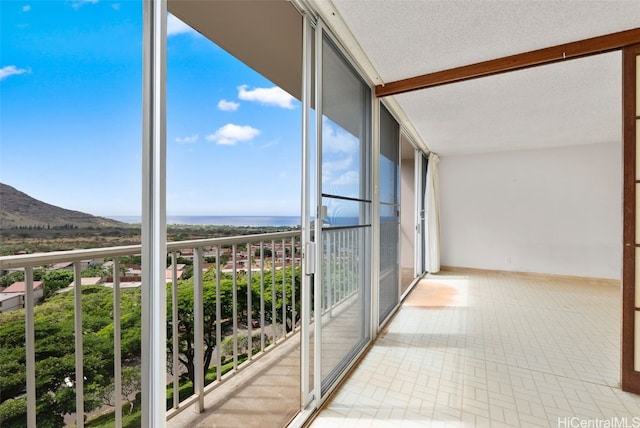 unfurnished sunroom featuring a water and mountain view