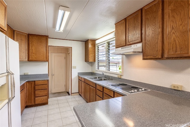 kitchen featuring sink, white refrigerator with ice dispenser, a textured ceiling, and cooktop