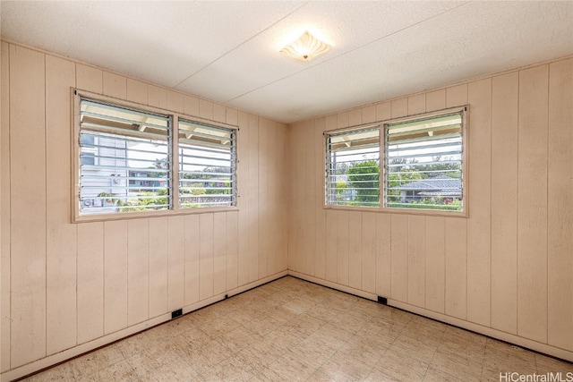 spare room featuring wooden walls