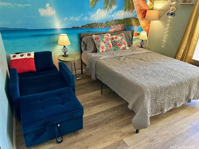 bedroom with a water view and hardwood / wood-style flooring