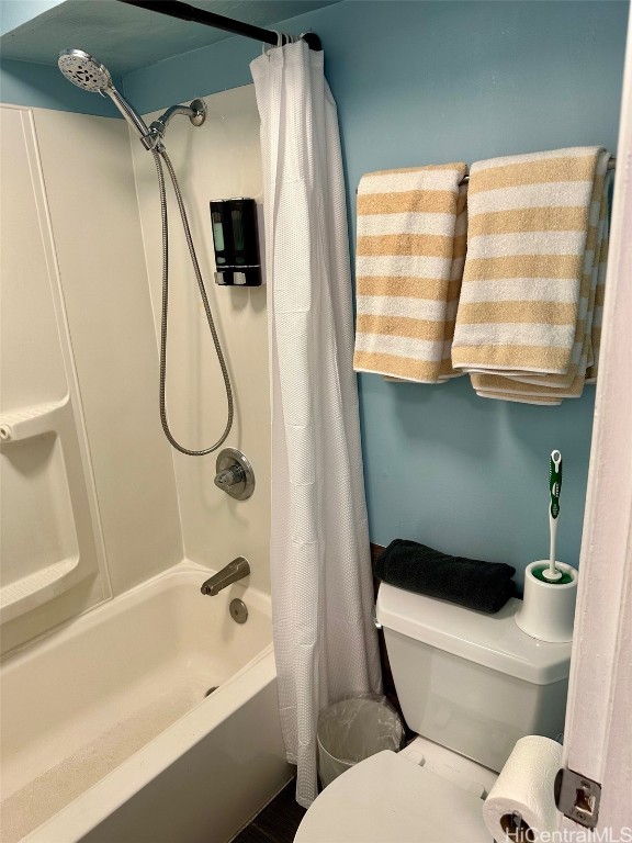 bathroom with toilet and shower / tub combo with curtain