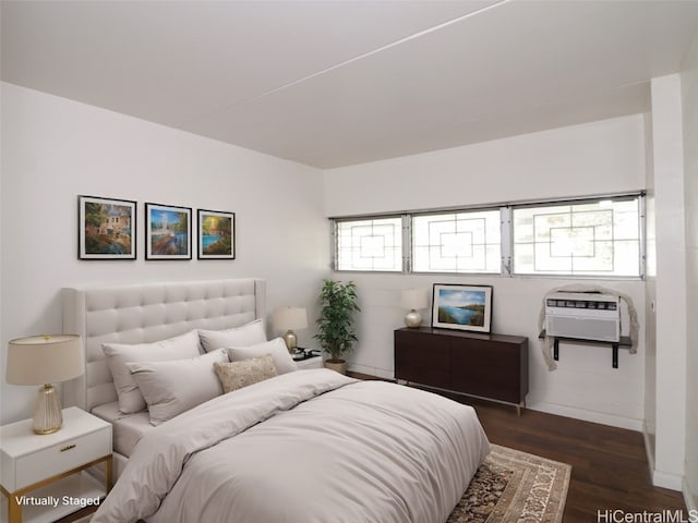 bedroom featuring a wall mounted AC and dark hardwood / wood-style flooring