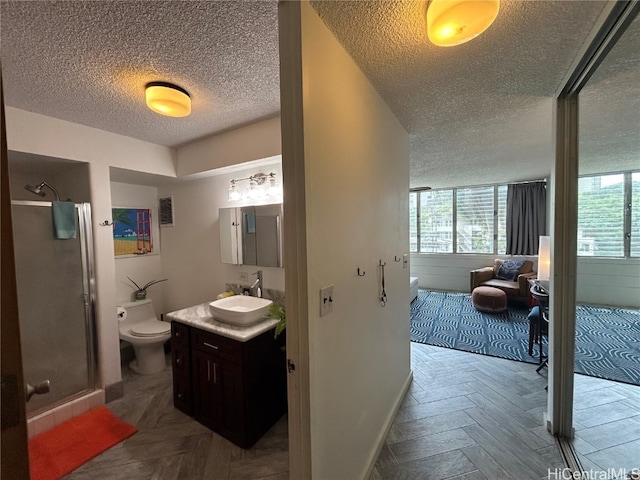 bathroom featuring toilet, parquet floors, vanity, a textured ceiling, and walk in shower