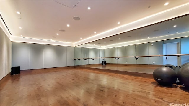 exercise room with light wood-type flooring