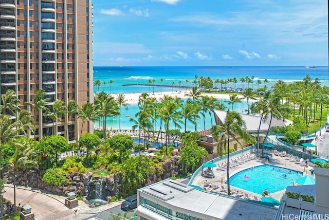 view of swimming pool with a water view, a patio, and a beach view