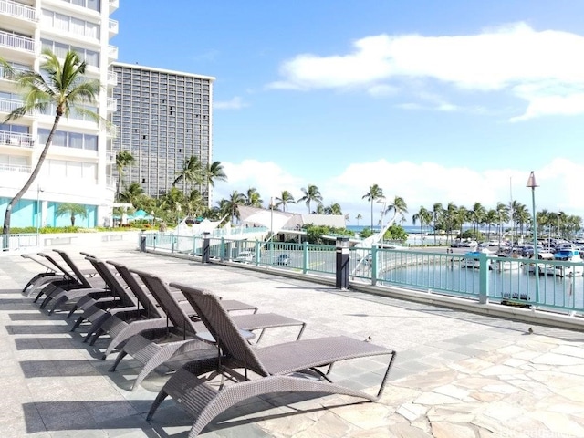 view of patio with a water view and a community pool