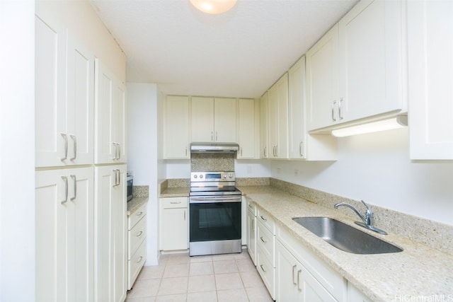 kitchen featuring light stone counters, stainless steel electric range oven, sink, light tile patterned floors, and white cabinetry