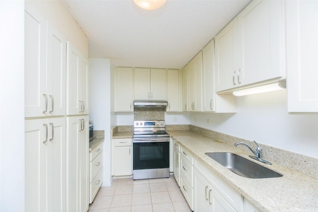 1561 Kanunu St Unit 1205, Honolulu, HI 96814 - kitchen with stainless steel electric range oven, a sink, under cabinet range hood, light tile patterned floors, and white cabinetry