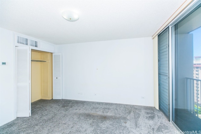 unfurnished bedroom featuring a closet, carpet floors, and a textured ceiling