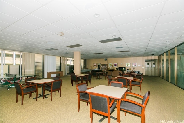 dining space with light carpet and a paneled ceiling