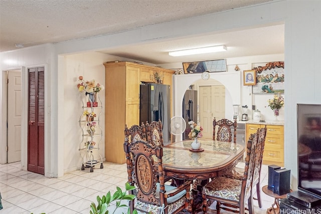 tiled dining space with a textured ceiling