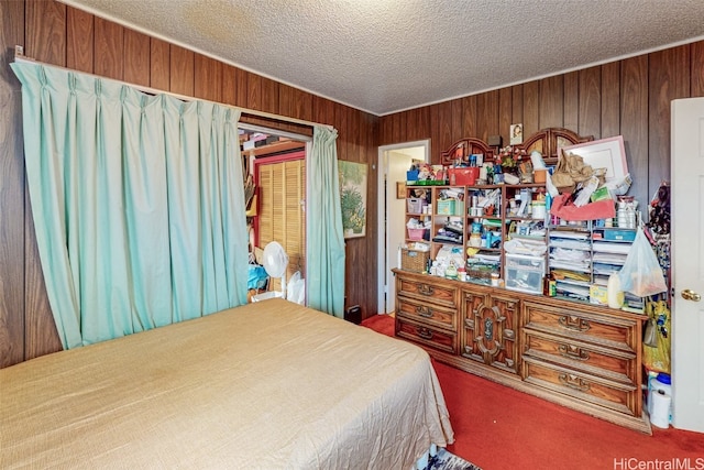 carpeted bedroom featuring wooden walls and a textured ceiling