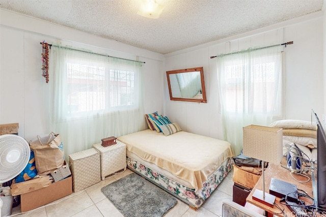 tiled bedroom featuring a textured ceiling