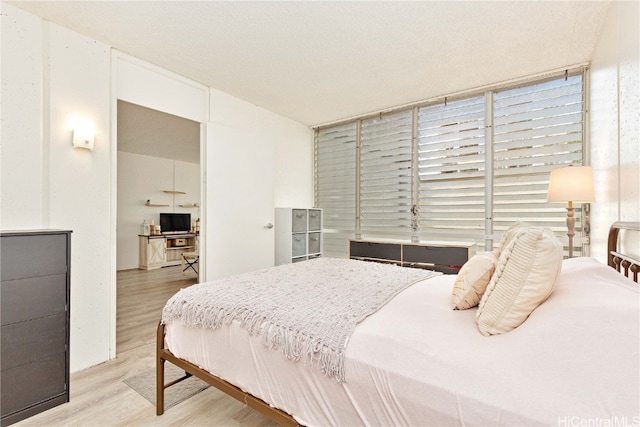 bedroom featuring a textured ceiling and light hardwood / wood-style floors