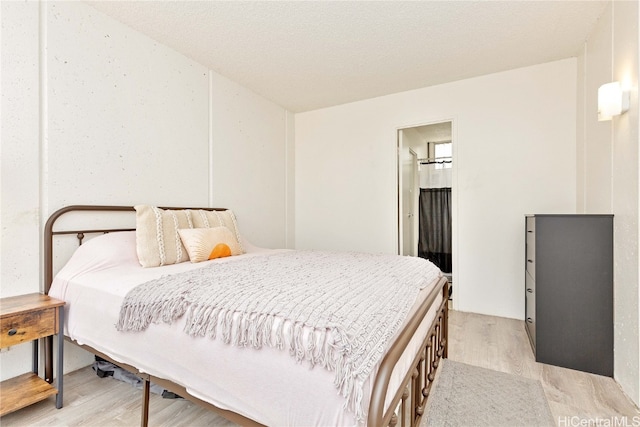 bedroom with a textured ceiling and light wood-type flooring