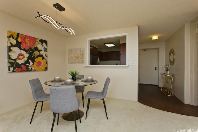 dining room with a textured ceiling and carpet