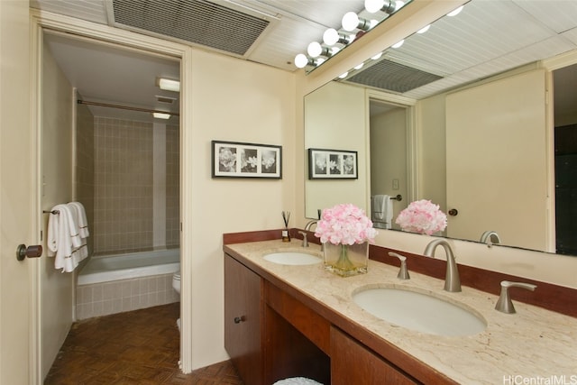 full bathroom featuring toilet, tiled shower / bath combo, vanity, and parquet flooring