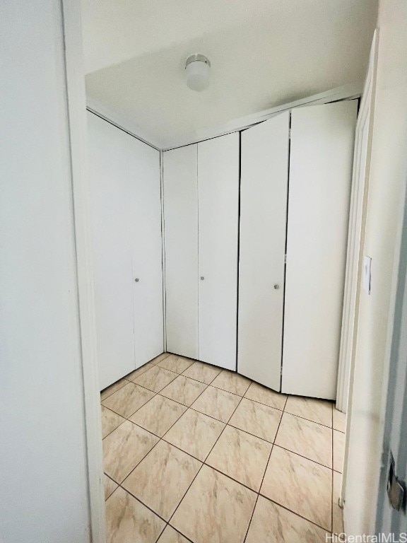 unfurnished bedroom with a closet and light tile patterned floors