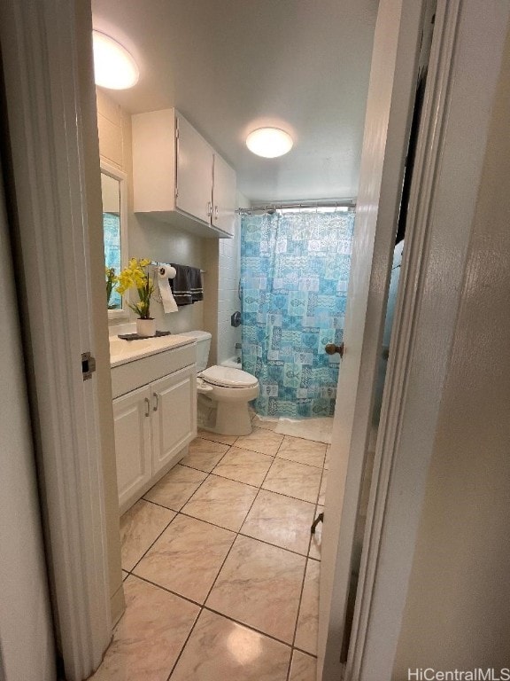 bathroom featuring toilet, walk in shower, vanity, and tile patterned flooring