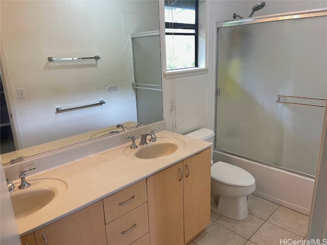 full bathroom featuring vanity, toilet, tile patterned floors, and bath / shower combo with glass door